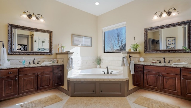 bathroom with two vanities, a sink, and a bath