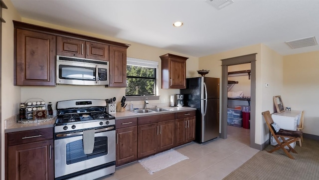 kitchen with light tile patterned floors, visible vents, stainless steel appliances, and a sink