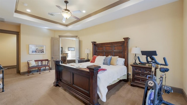 bedroom with light colored carpet, a tray ceiling, visible vents, and crown molding