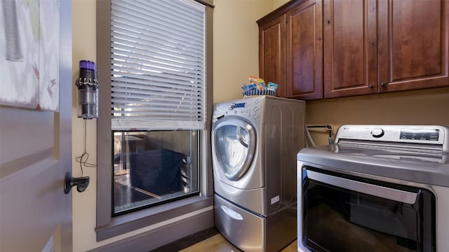 washroom featuring cabinet space and washing machine and dryer