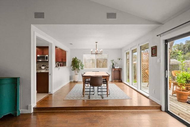 dining room with visible vents, a notable chandelier, and wood finished floors