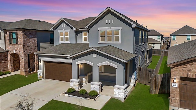 view of front of house with a garage, driveway, a lawn, and stucco siding