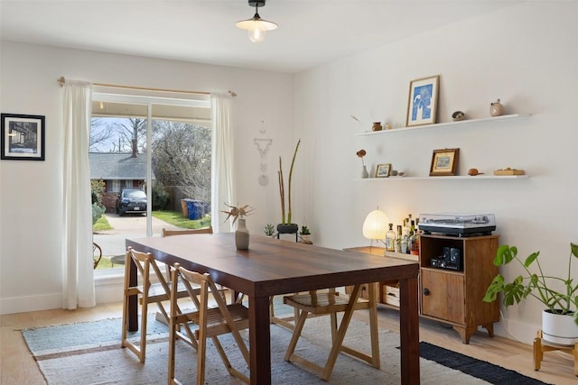 dining area with light wood-style flooring and baseboards