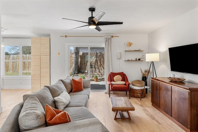 living room featuring light wood finished floors and a ceiling fan