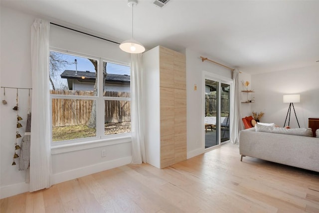 interior space with a wealth of natural light, baseboards, and wood finished floors