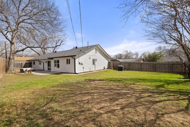 back of property featuring a yard, a fenced backyard, and a patio