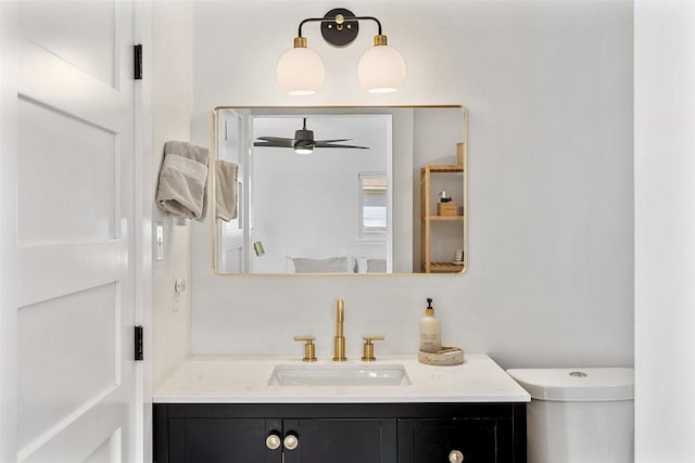 bathroom featuring toilet, ceiling fan, and vanity