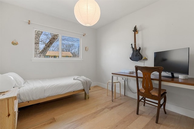 bedroom featuring baseboards and wood finished floors