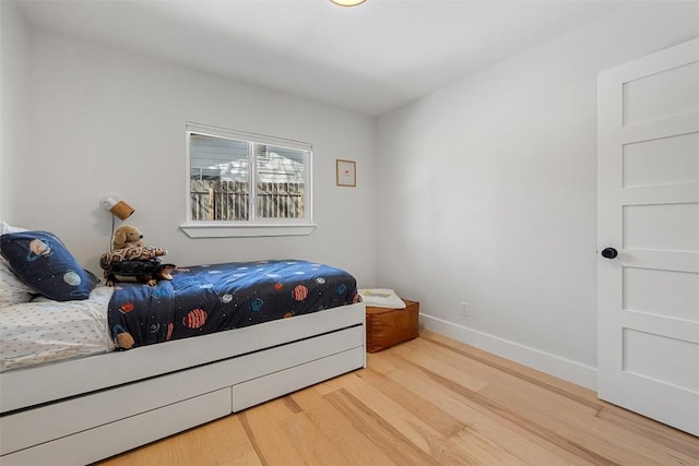 bedroom with baseboards and wood finished floors