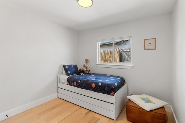 bedroom with baseboards and wood finished floors