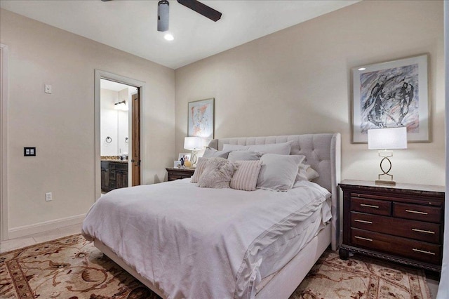 bedroom with light tile patterned flooring, ceiling fan, baseboards, and ensuite bathroom