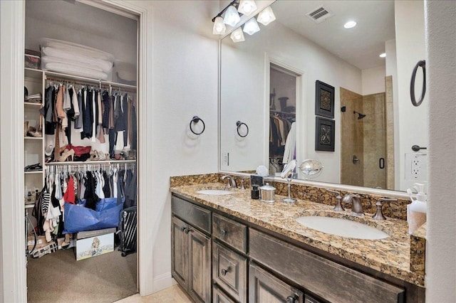 full bathroom with a stall shower, visible vents, a sink, and double vanity