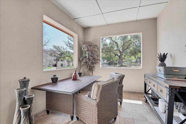 office area featuring light tile patterned floors, a drop ceiling, and baseboards