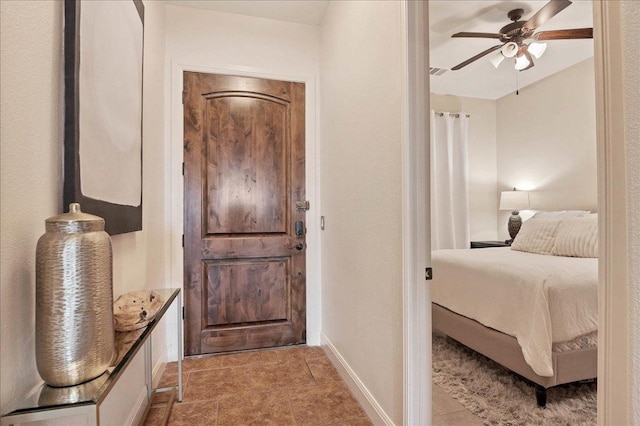 bedroom featuring a ceiling fan, visible vents, and baseboards