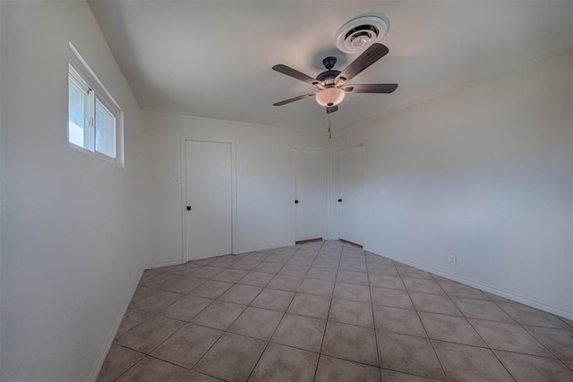 spare room featuring a ceiling fan, visible vents, and baseboards