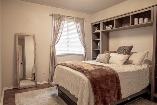 bedroom featuring wood finished floors and baseboards