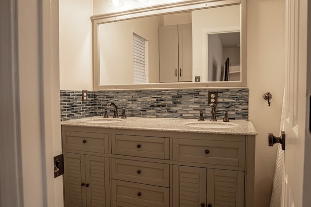 bathroom featuring double vanity, backsplash, and a sink