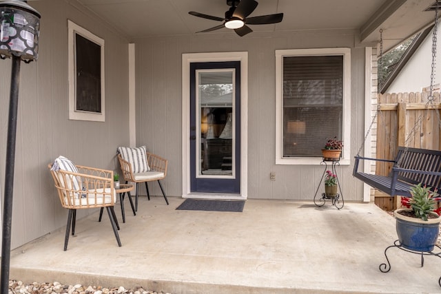 doorway to property with a patio area, fence, and a ceiling fan