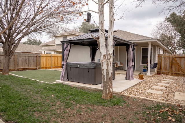 exterior space with a gazebo, a patio area, a fenced backyard, and a hot tub