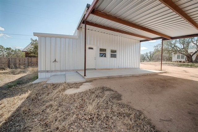 exterior space with a carport and fence