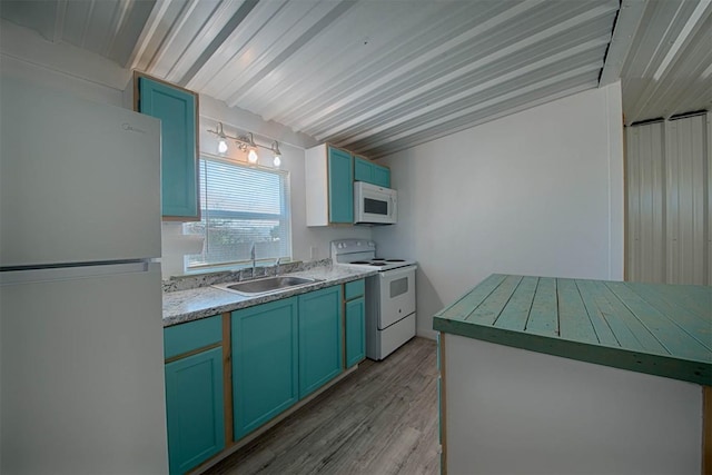 kitchen with white appliances, light wood-style flooring, light countertops, blue cabinetry, and a sink