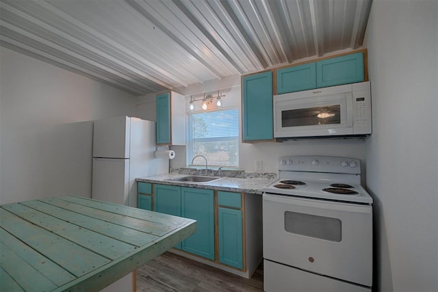 kitchen with white appliances, wood finished floors, blue cabinets, light countertops, and a sink