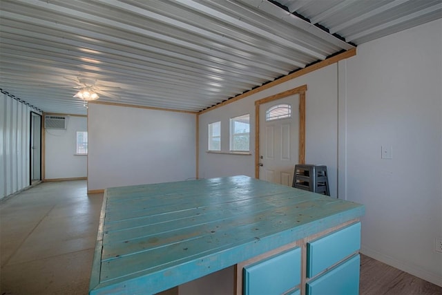 interior space with plenty of natural light, baseboards, and an AC wall unit