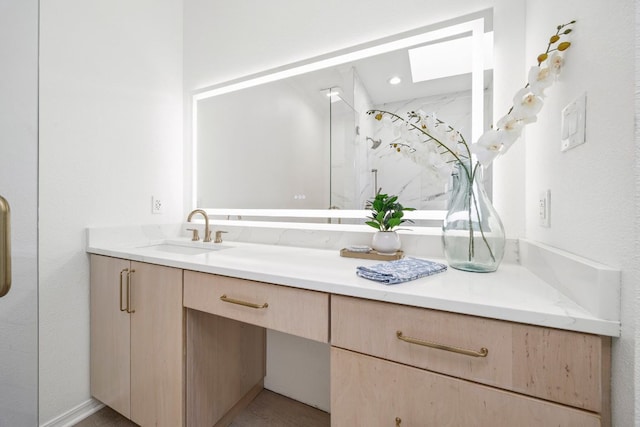 bathroom featuring a skylight and vanity