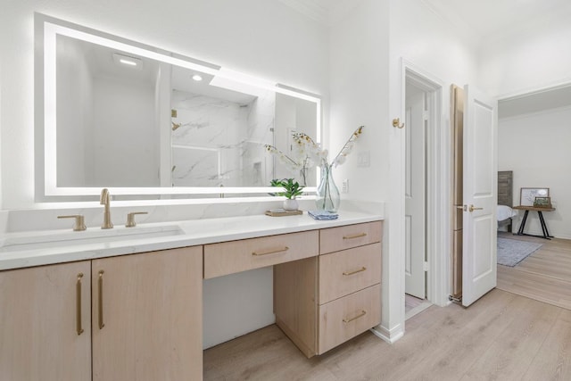 full bath with ornamental molding, ensuite bath, wood finished floors, and vanity