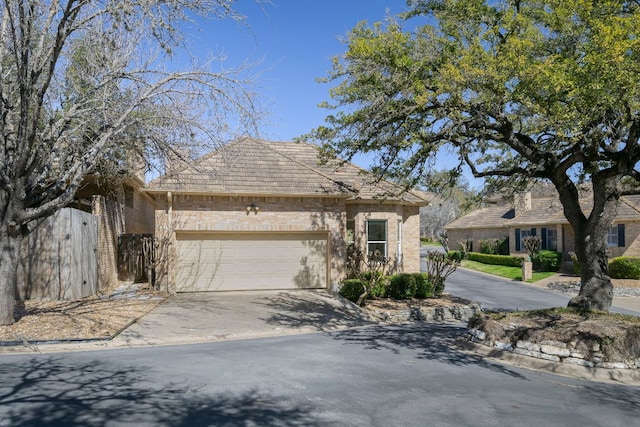 view of front of home featuring a garage, concrete driveway, and fence