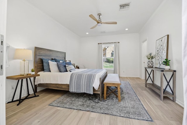 bedroom with baseboards, visible vents, wood finished floors, and ornamental molding