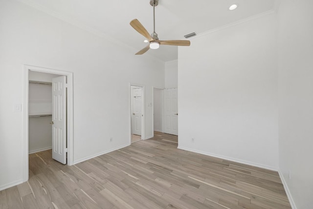 unfurnished bedroom featuring light wood-type flooring, baseboards, visible vents, and ornamental molding