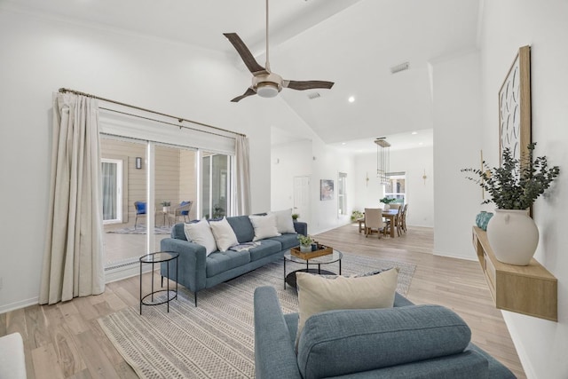 living area featuring light wood finished floors, visible vents, ceiling fan, high vaulted ceiling, and baseboards