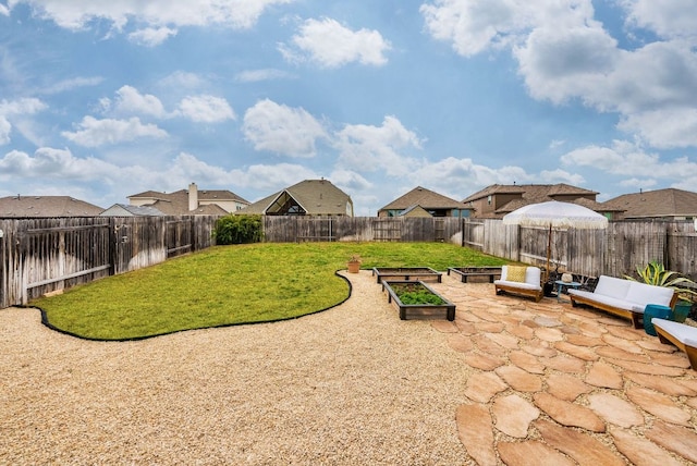 view of yard featuring a residential view, a fenced backyard, a patio, and a vegetable garden