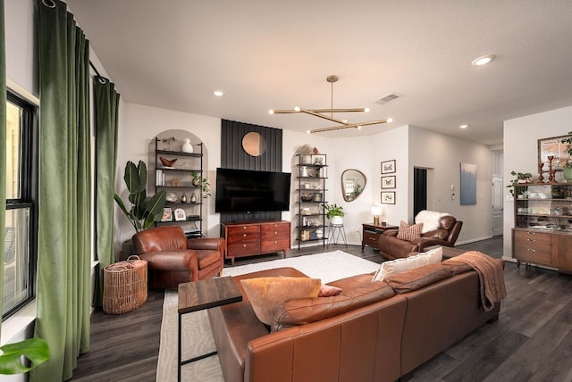 living room with dark wood-type flooring, recessed lighting, visible vents, and an inviting chandelier