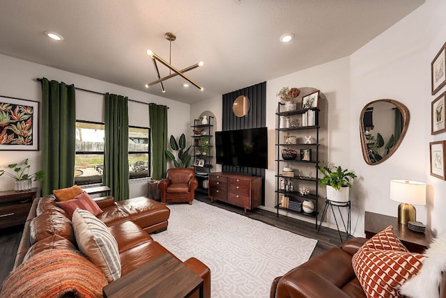 living room featuring an inviting chandelier, dark wood finished floors, and recessed lighting