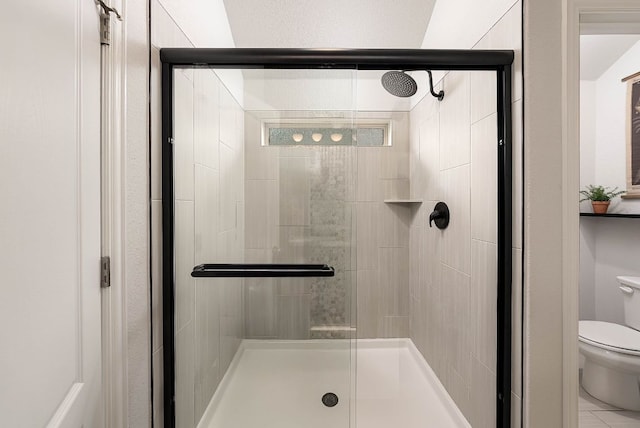 bathroom featuring a shower stall and toilet