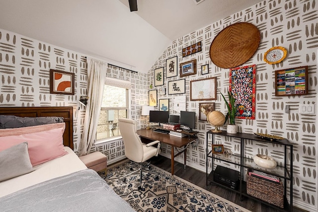 bedroom with lofted ceiling, wood finished floors, and wallpapered walls