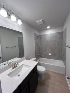 bathroom with shower / bath combination, vanity, and toilet