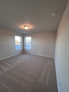 carpeted spare room with baseboards