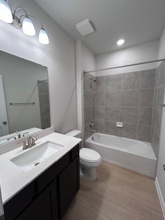 bathroom with toilet, vanity, and shower / bathtub combination