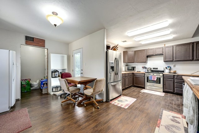 kitchen featuring stainless steel appliances, dark brown cabinets, dark wood-style flooring, and light countertops