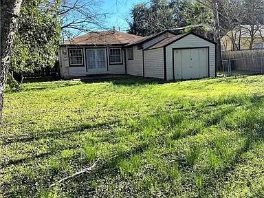 view of yard with an outbuilding, french doors, a storage unit, and fence