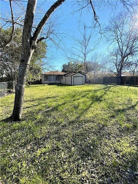 view of yard featuring a fenced backyard and an outbuilding