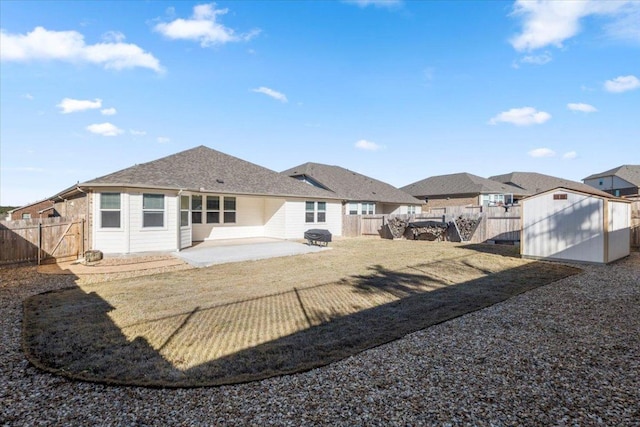 back of house with a patio area, a shed, a fenced backyard, and an outdoor structure