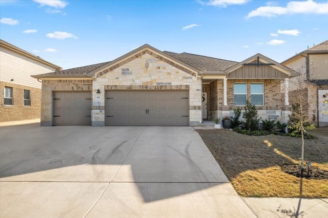 view of front of house with a garage, stone siding, driveway, and board and batten siding