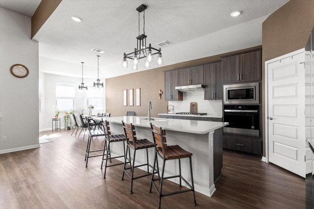 kitchen with a notable chandelier, a sink, visible vents, light countertops, and appliances with stainless steel finishes