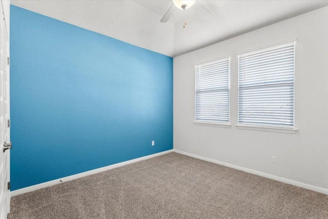 carpeted empty room with ceiling fan and baseboards