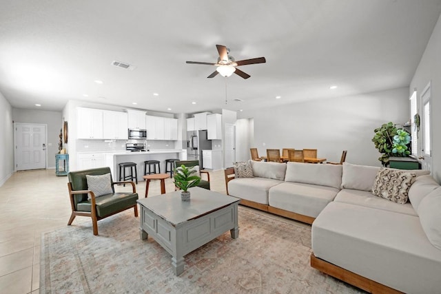 living room featuring a ceiling fan, recessed lighting, visible vents, and light tile patterned floors