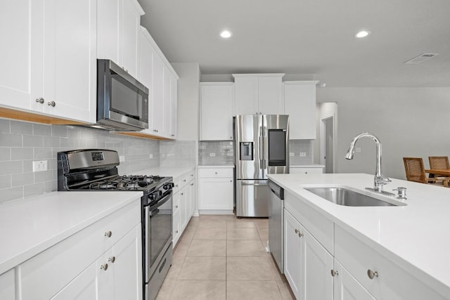 kitchen featuring light tile patterned floors, stainless steel appliances, light countertops, visible vents, and a sink